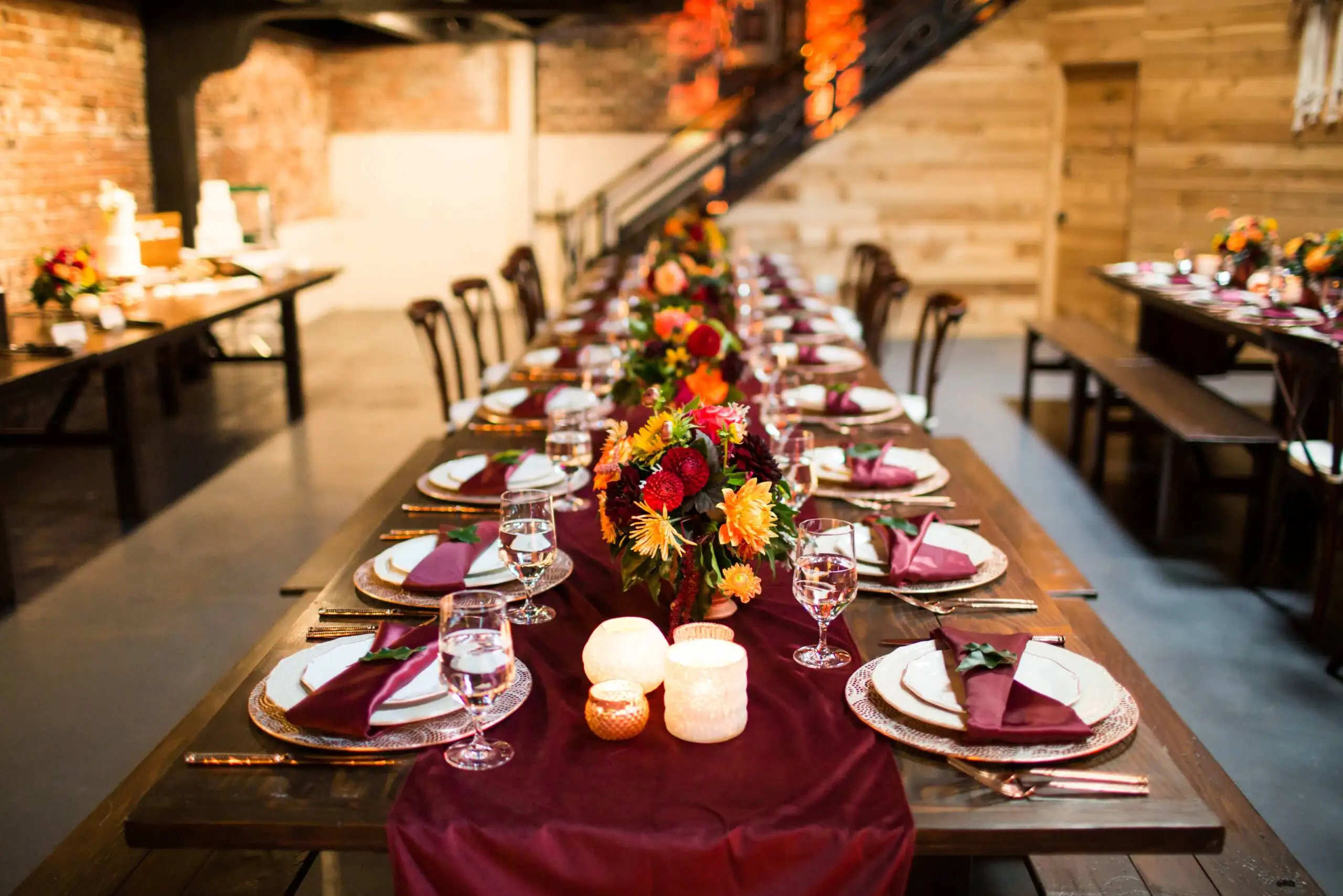 A long table with luxury plates and decorated with colorful flowers and candles